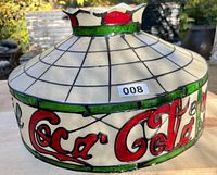 Side view of vintage Coca-Cola fiberglass/resin shade showing red Coca-Cola logo and crown upper design