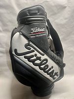 Side view of black and white vintage Titleist Pro Staff golf carry bag showing large Titleist logo on side pocket and Pro-Trajectory branding.