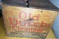 Front view of the Old Dutch Cleanser wooden box showing faded red and black text and some wear marks.