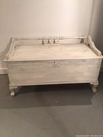 Exterior view of the heirloom cedar chest showing distressed white paint, carvings on backrest, and four cabriole legs.