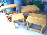 Overall photo of pine wood furniture set with magazine/book rack and three small tables showing wear and scratches.