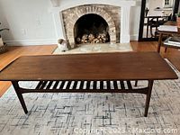 Front view of long rectangular coffee table with slatted shelf under tabletop