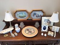 Overview of the lot showing lamps, framed prints, porcelain, glassware and small decorative items