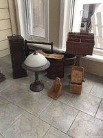 Front view of all items showing the stacked baskets, saddle seat, lamp, and wooden containers