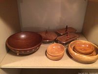 Shelved view showing all wooden bowls together with glass serving dishes with wooden lids