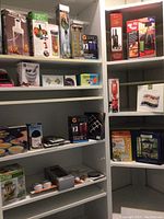 Wide view of shelves with various boxed kitchen gadgets and novelty items, mostly unopened boxes.