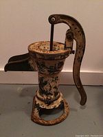 Front and side angle of vintage water pump showing lever and spout.