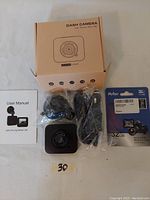 Overview photo showing the boxed dash camera, user manual, suction mount, USB cable, and 32GB Netac SD card