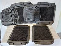 Four all-season car floor mats laid out on a white background, showing two larger front mats with molded rubber sections and carpet interior, and two smaller rear mats with similar design.