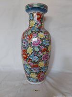 Full front view of the tall cloisonne vase showing floral patterns and gold wire detailing.