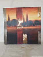 Front view of gold and red tree scape print on square canvas.