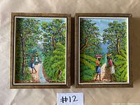 Two framed original acrylic paintings side by side, showing detailed outdoor scenes with people among trees and greenery
