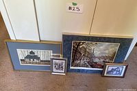 Four framed landscape and architectural art prints grouped on floor, showing variety of sizes and styles.