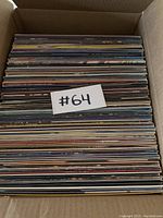 Box filled with numerous vinyl records packed tightly together.