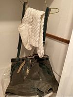 Brown suede lederhosen shorts with suspenders and cream knit socks draped over the suspenders