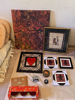 Photo of all items in the lot including wall art, framed textile, plaques, candle holders, and small decorative objects.