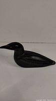 Side view of the black soapstone loon carving showing the bird's body and head shape.
