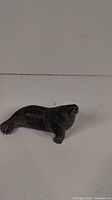 Front side view of the dark soapstone walrus sculpture showing detailed body and face.