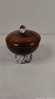 Front view of the MCM smokey art glass covered candy dish showing the rounded smokey brown lid and clear twisted base.