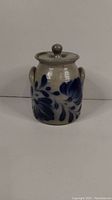 Front view of the cobalt blue floral patterned Salmon Falls pottery jar with lid. Shows the jar's loop handles and lid knob.