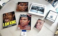 Overall view of the 6 items on a round table showing Muhammad Ali on various book and magazine covers.