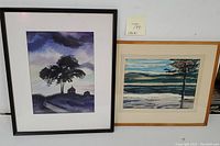 Two framed watercolor landscape paintings displayed together on wall, showing size comparison and framing details.