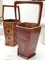 Two Chinese lacquer baskets side by side showing painted floral motifs and wooden handles