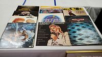Top view of 10 vinyl album covers laid out in two rows on a table.