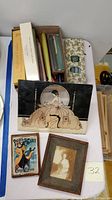 Full lot view showing vintage art portraits including painting on glass, framed photo, and assorted candles with boxes.