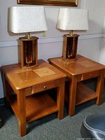 Photo showing pair of wooden side tables with inlaid wood tops and two vintage lamps with rectangular fabric shades.