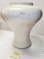 Front and side view of large white glazed studio pottery vase showing bulbous shape and narrow base.