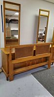Rear view of queen-size wooden headboard showing panel design and integrated wood details.