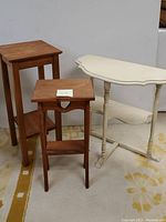 Set of three wooden tables including two natural wood tables with heart cutout detail and one white painted table with turned legs.
