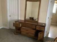 Full view of the wooden dresser with some drawers and doors open, showing the overall design and condition.