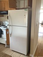Full view of white Whirlpool refrigerator in kitchen setting