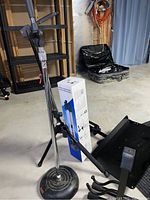 Wide view of the music and microphone stands along with tripod box and stands in a basement room.