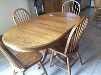 View of oak oval pedestal table with chairs set