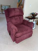 Front-left perspective of burgundy corduroy recliner showing overall shape and lever