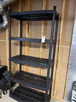 Front and angled views of the black resin shelving unit showing its 5 lattice shelves and overall tall frame.