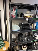 Full view of shelving unit with various kitchen and small appliances stored on it, showing overall condition and design.