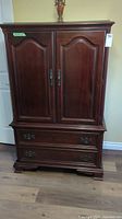 Front view of full armoire showing double doors and two bottom drawers