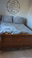 Front view of assembled queen sleigh bed frame with bedding removed