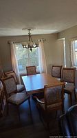 Full dining set in room: table with leaves installed and ten chairs