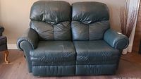 Front view of two-seat green leather reclining loveseat