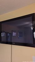 Samsung 42-inch flat screen TV mounted on wall, black frame visible