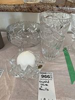 Clear cut crystal items consisting of a tall vase, large bowl, and star-shaped candle holder with candle.