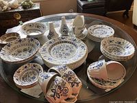 Full assortment of Blue Nordic dishes and J&G Meakin dessert dishes displayed on a glass table to show quantity and style.