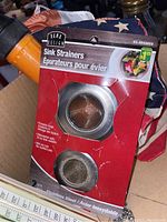 Photo of stainless steel stainless steel sink strainers in original Rama Design packaging.