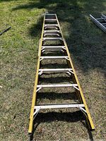 Full view of ladder laid flat on grass showing entire 10-foot length