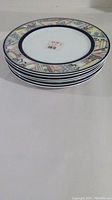 Stack of 6 Hutschenreuther salad/lunch plates with decorative border featuring houses and dark blue inner band.
